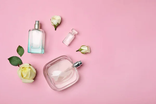 Şişe parfüm ve gül renkli arka plan, üstten görünüm üzerinde — Stok fotoğraf