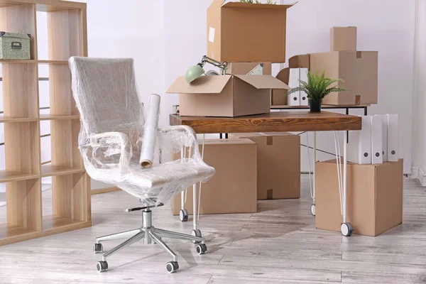 Sillón y cajas de cartón con cosas en la habitación. concepto de movimiento de oficina —  Fotos de Stock