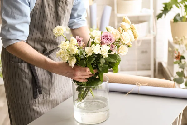 Floristería masculina creando composición floral en el lugar de trabajo —  Fotos de Stock