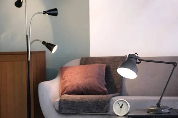 Modernes Wohnzimmerinterieur mit Lampen und bequemem Sofa — Stockfoto