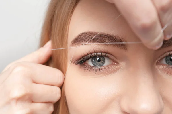 Young woman having professional eyebrow correction procedure in beauty salon — Stock Photo, Image