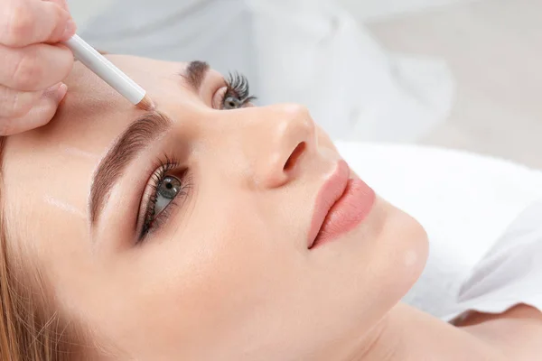 Genç kadın kaş kalıcı makyaj yordamı için closeup hazırlanıyor güzellik uzmanı