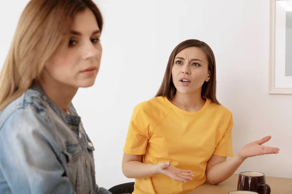 Women arguing at table in room — Stock Photo, Image