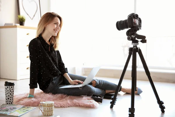 Young blogger with laptop recording video on floor at home — Stock Photo, Image