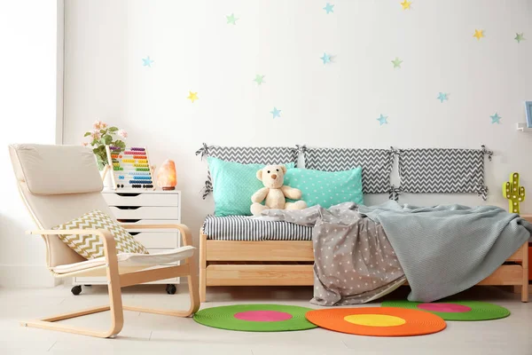 Chambre enfant moderne intérieur avec lit confortable et fauteuil — Photo