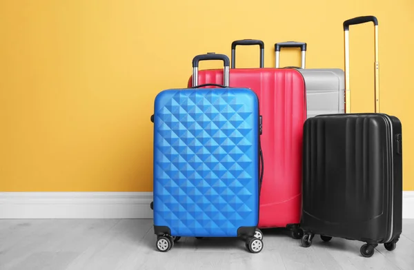Різні валізи біля кольорової стіни — стокове фото