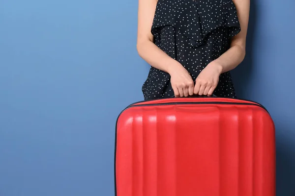 Mujer joven con maleta sobre fondo de color — Foto de Stock