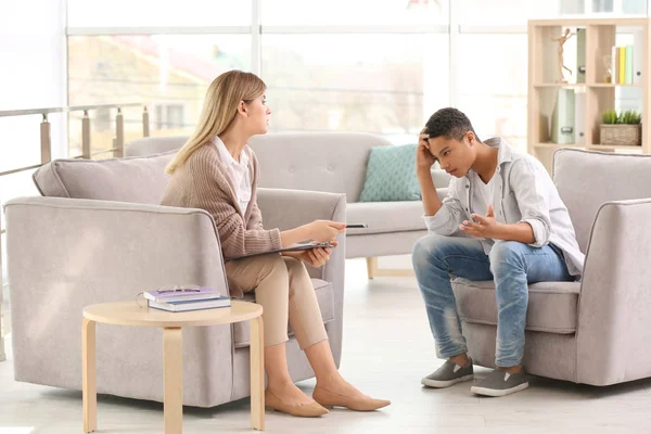 Young female psychologist working with teenage boy in office — Stock Photo, Image