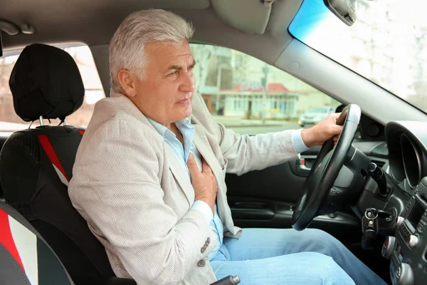 Старший мужчина, страдающий от сердечного приступа в машине — стоковое фото