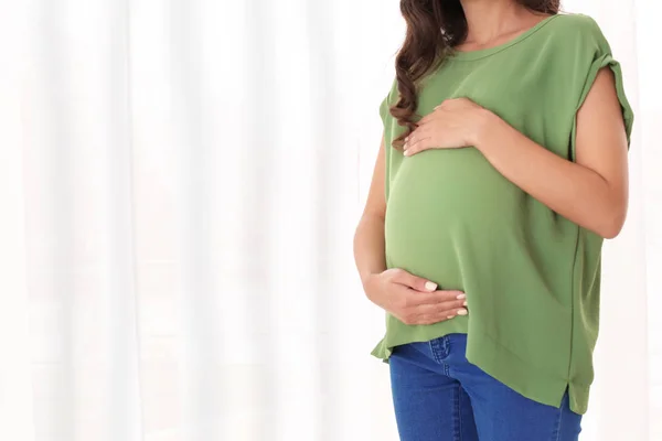 Bella donna incinta vicino alla finestra a casa — Foto Stock