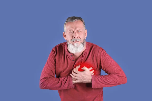 Mature man having heart attack on color background — Stock Photo, Image