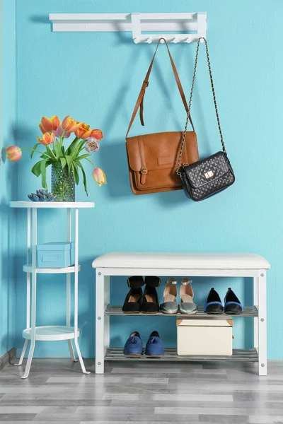 Storage bench with different female shoes indoors