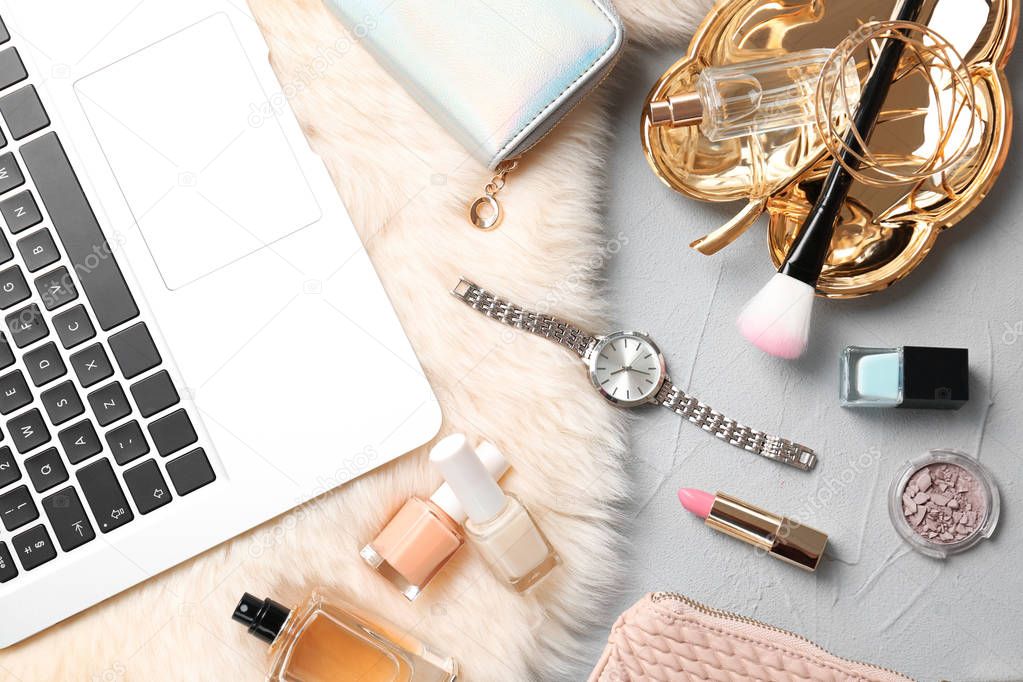 Set of accessories, cosmetics and laptop on grey background, flat lay. Beauty blogging