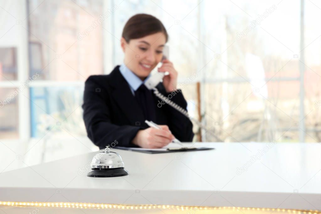 Service bell and female receptionist in hotel