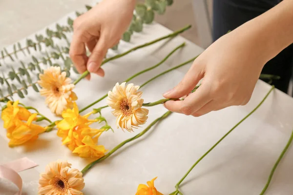 Floristería femenina haciendo hermoso ramo en la mesa —  Fotos de Stock