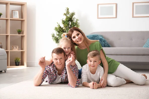 Šťastná rodina na útulné koberci doma — Stock fotografie