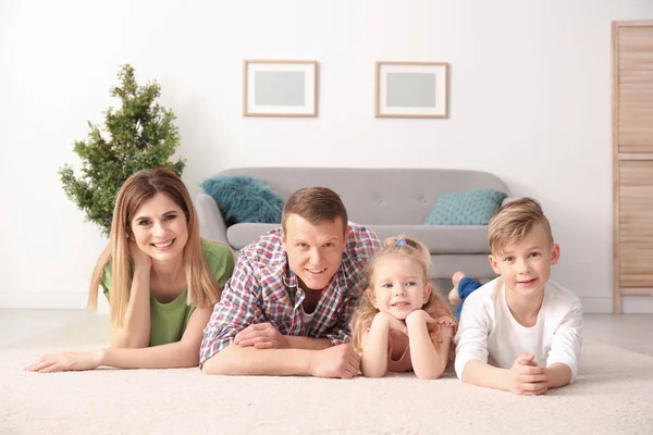 Liggend op de gezellige tapijt thuis en gelukkige familie — Stockfoto