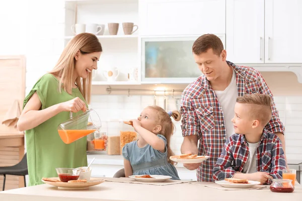 キッチンのテーブルで両親とかわいい子供たちとおいしい朝食トースト — ストック写真