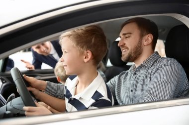 Genç aile yeni araba satıcısı ile salonda seçimi