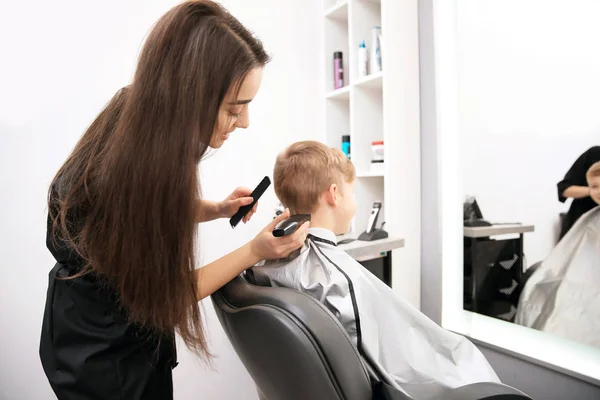 Professionelle Friseurin arbeitet mit kleinem Jungen im Salon — Stockfoto