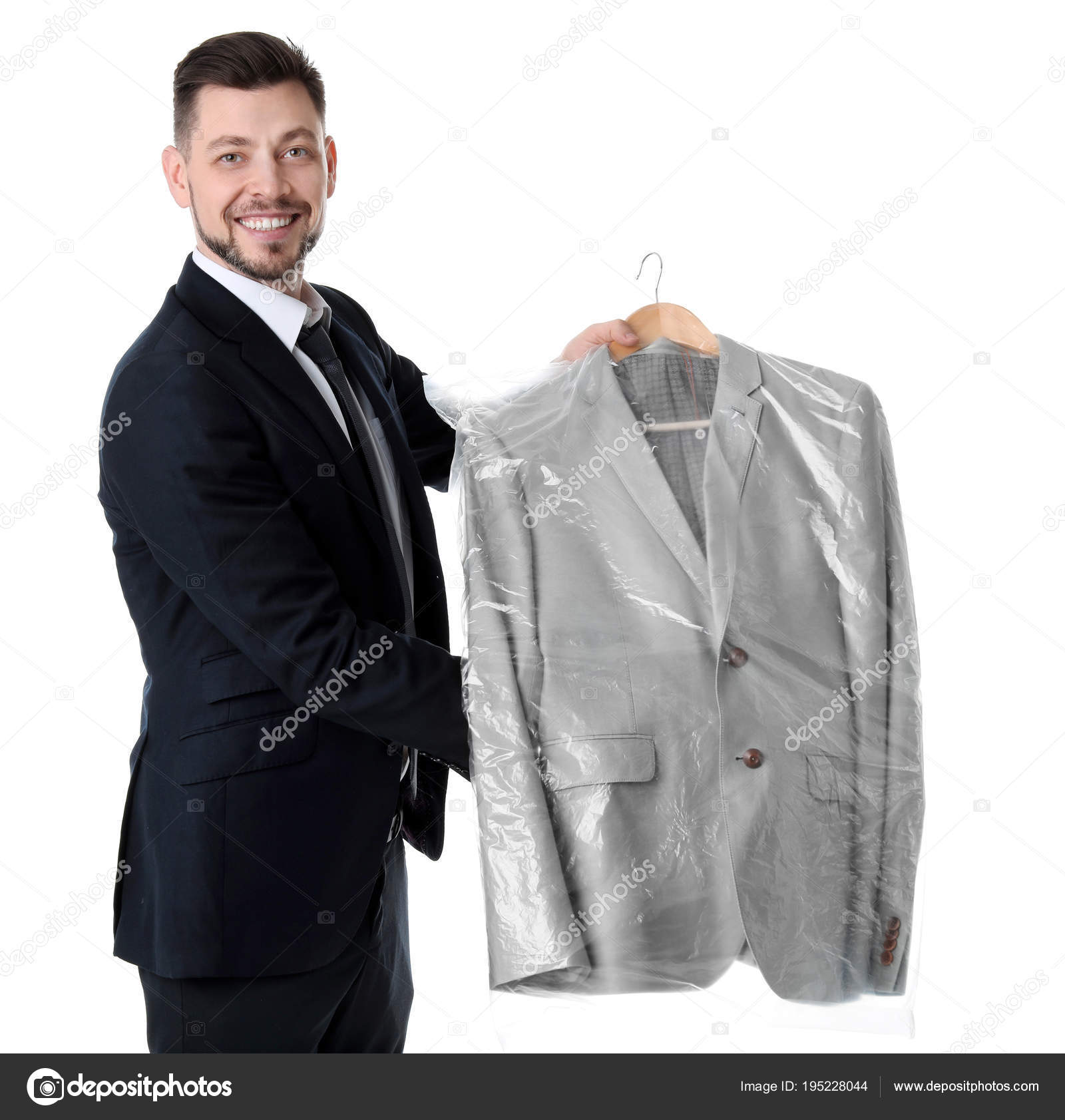 Young businessman holding hanger with jacket in plastic bag on white  background. Dry-cleaning service Stock Photo by ©NewAfrica 195228044
