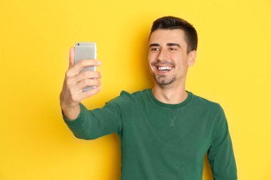 Yakışıklı delikanlı selfie renk arka plan karşı alarak