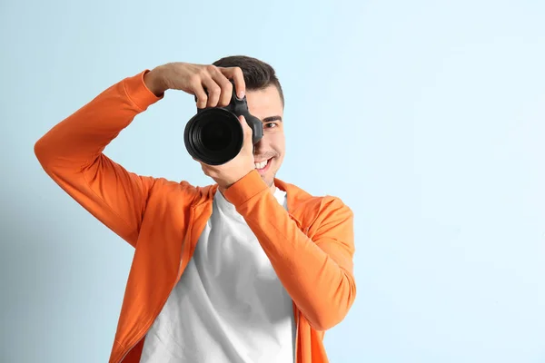 Male photographer with camera on light background — Stock Photo, Image