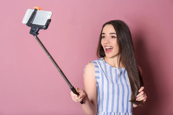 Junge schöne Frau macht Selfie vor farbigem Hintergrund — Stockfoto