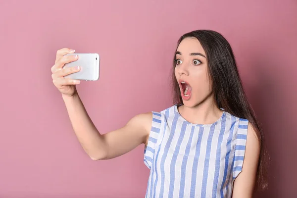 Tineri femeie frumoasă luând selfie pe fundal de culoare — Fotografie, imagine de stoc