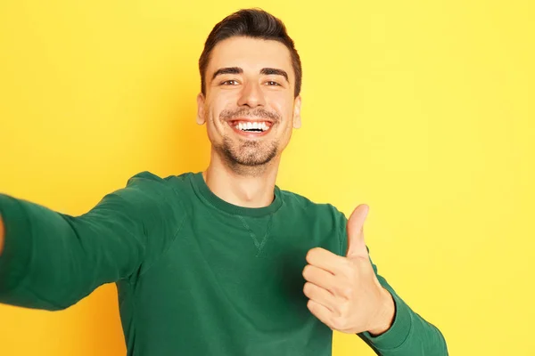 Joven hombre guapo tomando selfie contra el fondo de color — Foto de Stock