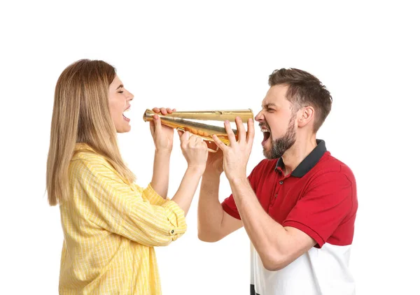 Young woman and man shouting into megaphone on white background — Stock Photo, Image