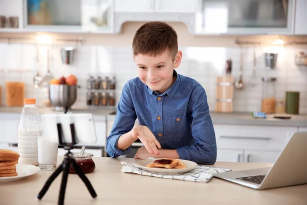 Cute little blogger with food recording video on kitchen