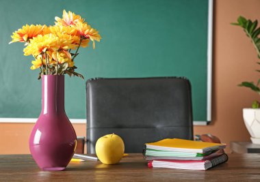 Buket çiçek, elma ve defter sınıf tablo üzerinde. Öğretmen günü kutlama