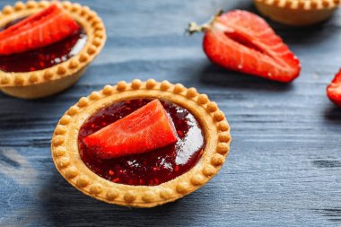 Ahşap arka plan üzerinde çilek reçeli ile lezzetli tartlets
