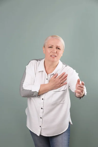 色の背景上心臓発作を持つ成熟した女性 — ストック写真