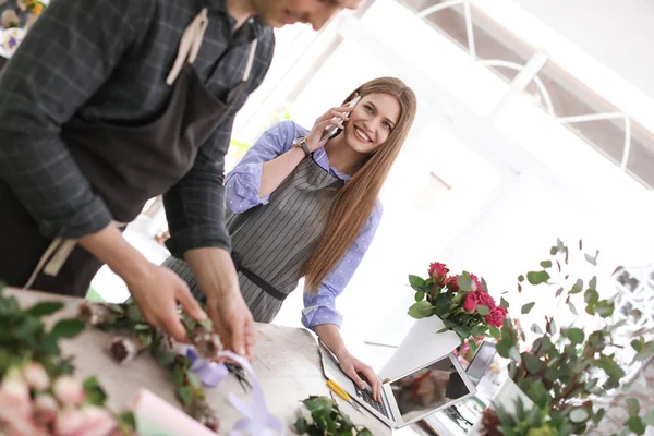 Floristerías masculinas y femeninas que trabajan en florerías — Foto de Stock