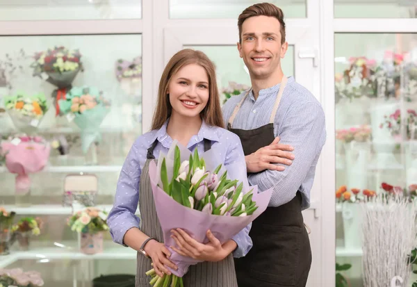 Floristas masculinos y femeninos con flores de ramo en el lugar de trabajo — Foto de Stock