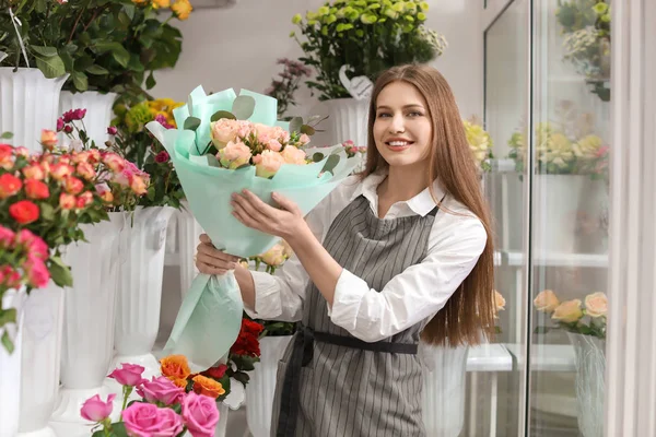 Floristería femenina sosteniendo flores de ramo en el lugar de trabajo — Foto de Stock