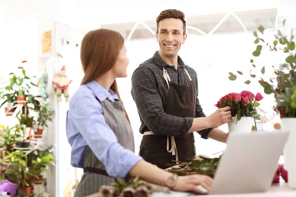 Floristerías masculinas y femeninas que trabajan en florerías — Foto de Stock