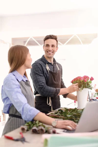 Floristerías masculinas y femeninas que trabajan en florerías — Foto de Stock