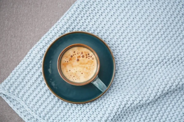 Kopp kaffe och pläd på grå bakgrund, ovanifrån — Stockfoto