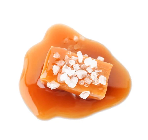 Deliziosa caramella con salsa al caramello e sale su sfondo bianco — Foto Stock