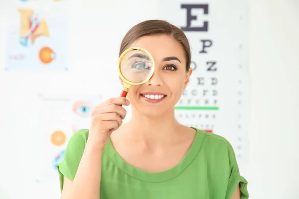 Jonge vrouw met Vergrootglas bezoekende oogarts — Stockfoto