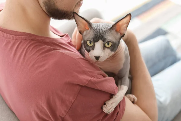 Молодой человек с милым котом дома — стоковое фото