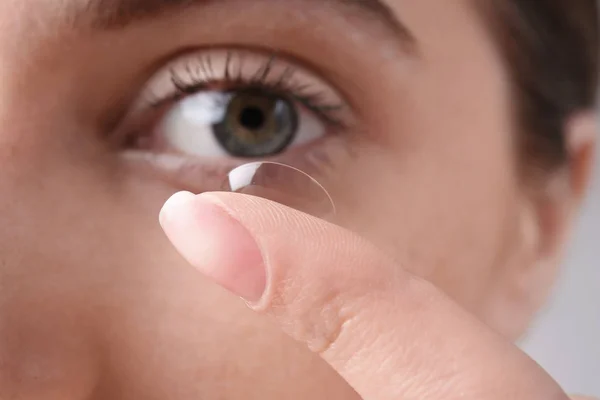 Mulher jovem colocando lente de contato em seu olho, close-up — Fotografia de Stock