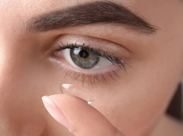 Mulher jovem colocando lente de contato em seu olho, close-up — Fotografia de Stock