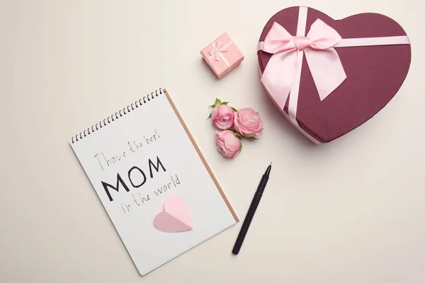 Composição de leigos planos com caderno, flores e presentes para o dia das mães no fundo claro — Fotografia de Stock