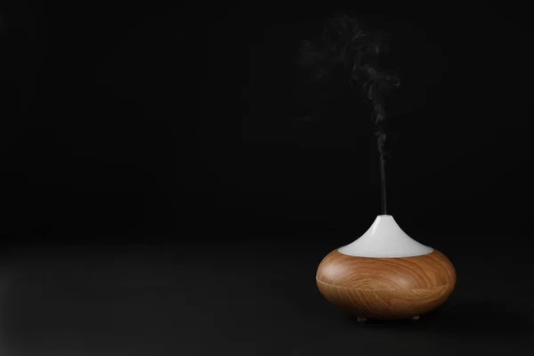 Aroma olie diffusor op zwarte achtergrond. Air verfrissing — Stockfoto