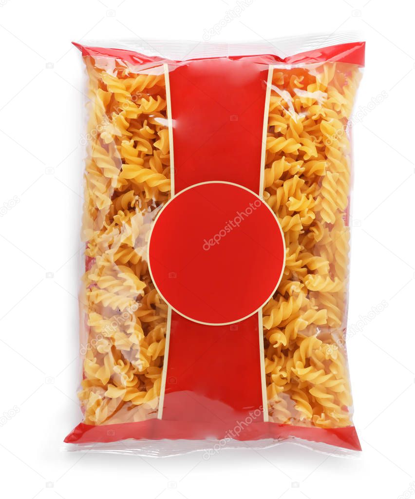 Uncooked fusilli pasta in plastic bag on white background, top view