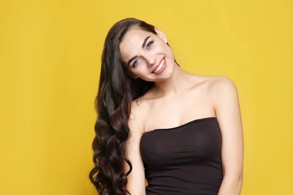 Retrato de modelo bonito com cabelo encaracolado lindo no fundo de cor — Fotografia de Stock